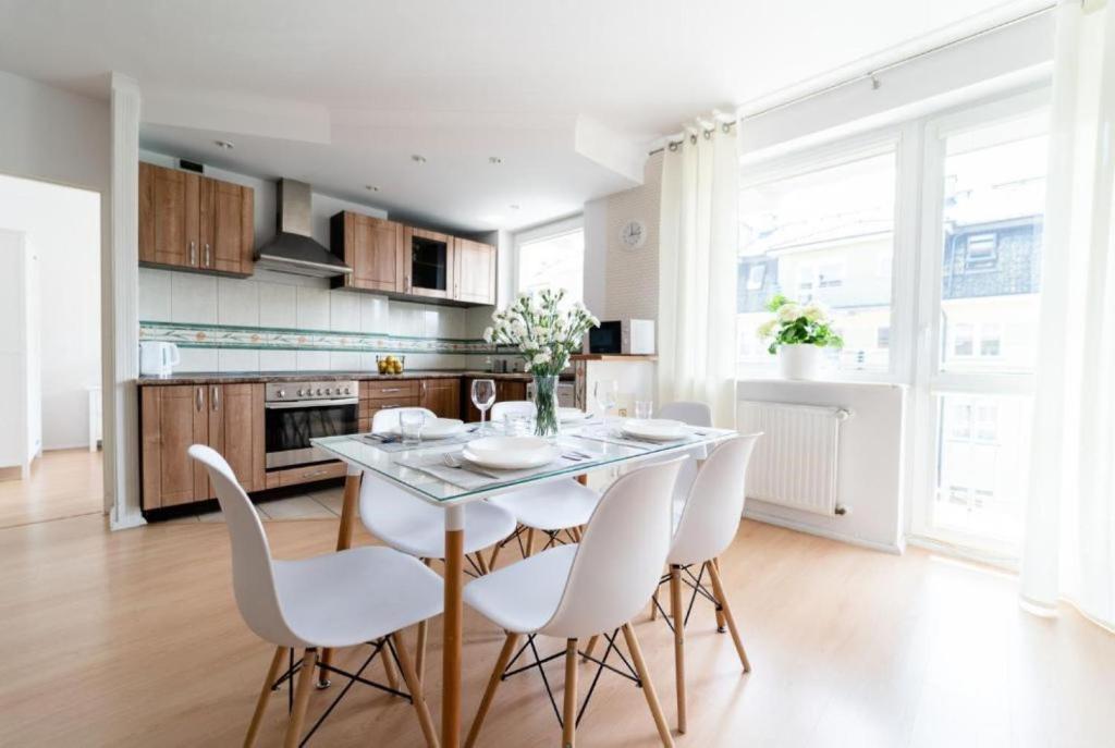 uma cozinha com mesa e cadeiras num quarto em Apartamenty Bałtyckie - Na Wydmie - winda, bezpłatny parking, 100m od port em Ustka
