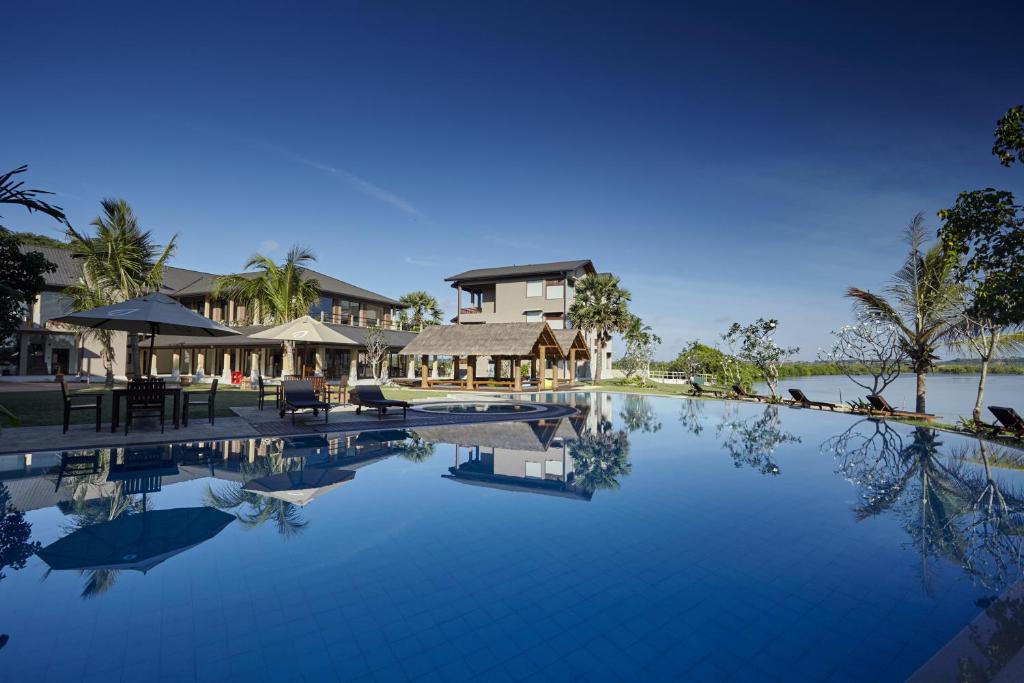 un complexe avec une grande piscine à côté d'un bâtiment dans l'établissement Amaranthe Bay Resort & Spa, à Trincomalee