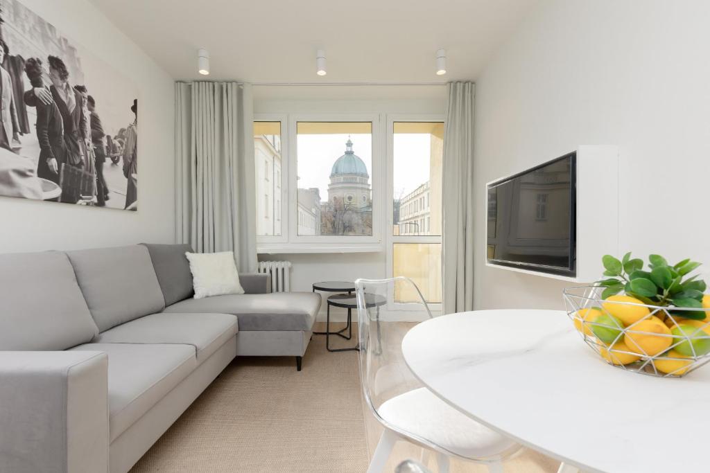 a living room with a couch and a table at Cosy Dream City Center Apartment by Renters in Warsaw