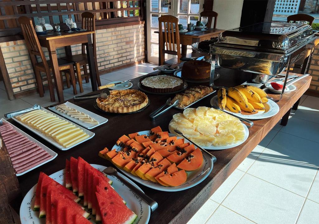 a table topped with lots of different types of food at Pousada Lua Cheia in Búzios