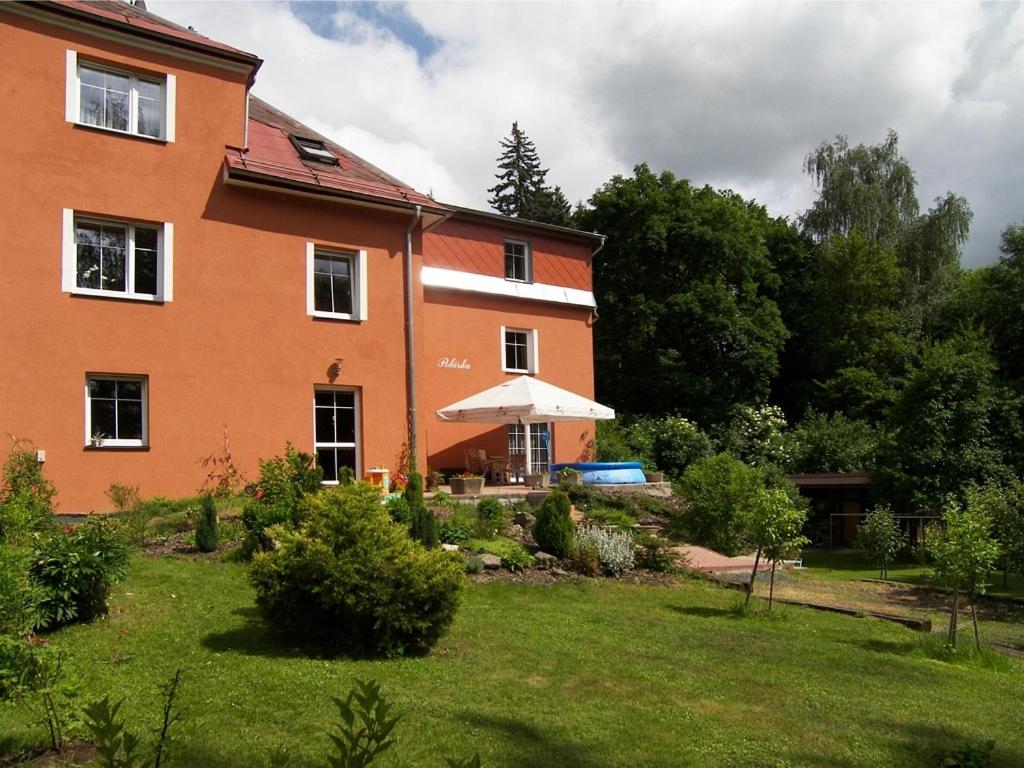 Una casa grande de color naranja con un jardín enfrente. en Penzion Polarka, en Mariánské Lázně