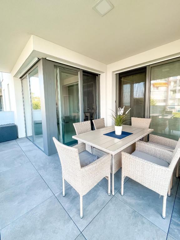 patio ze stołem i krzesłami na ganku w obiekcie MyFlat Viewpoint 57 w Siófoku