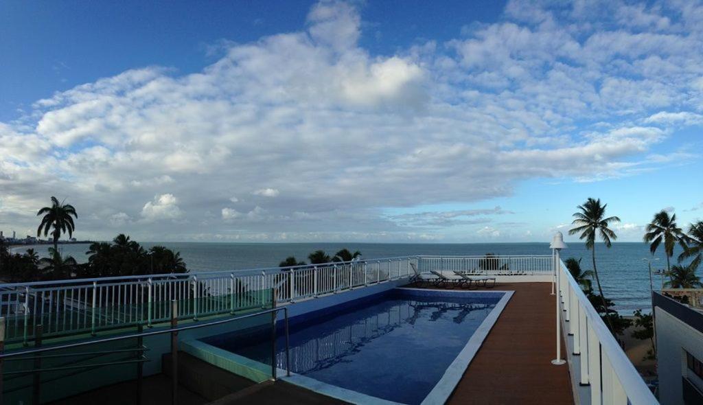 a swimming pool on top of a building overlooking the ocean at Apartment Cabo Branco #4 in João Pessoa