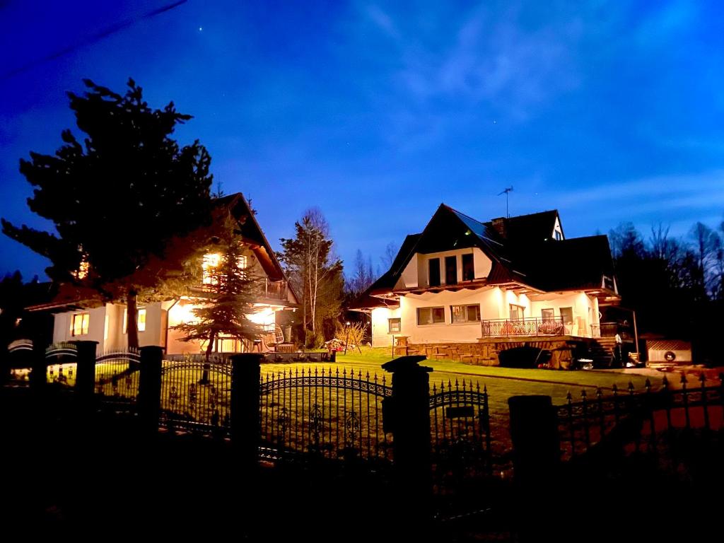 a house with a fence in front of it at night at Willa Skała in Kościelisko