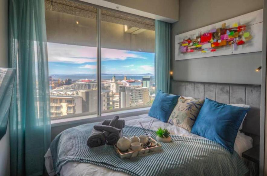 1 dormitorio con 1 cama y ventana grande en Executive City Micro Living in Long Street at One Thibault en Ciudad del Cabo