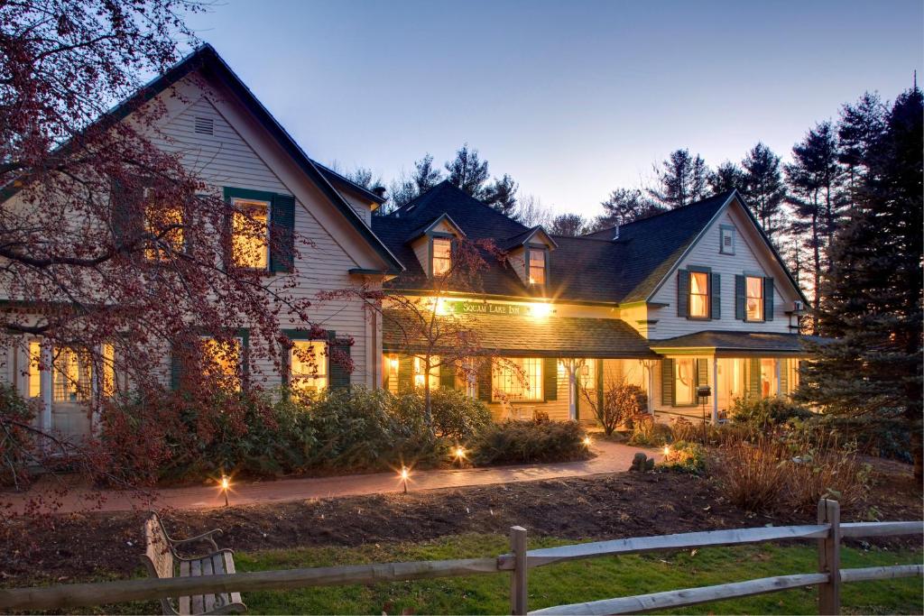 a house with lights on the front of it at Squam Lake Inn in Holderness