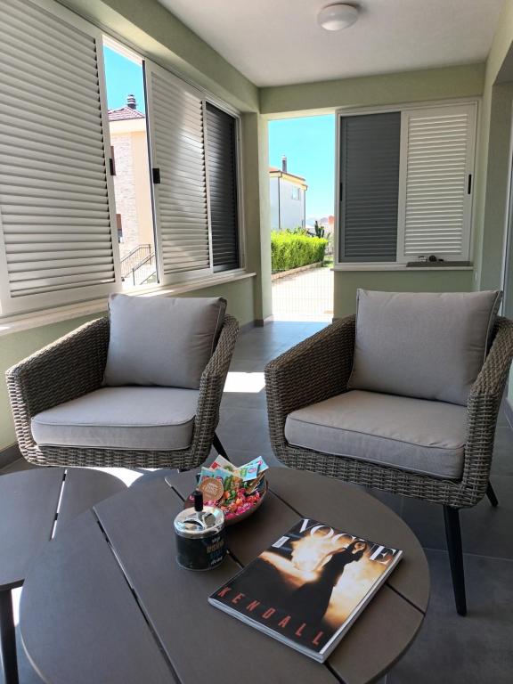 two chairs and a coffee table in a living room at DREAMS APARTMENT KAŠTELA in Kaštela