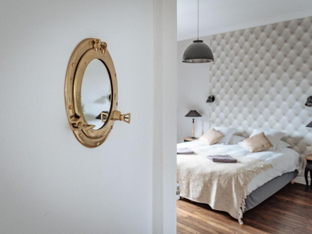 1 dormitorio con cama y espejo en la pared en La Villa Côté Cour en Dinan