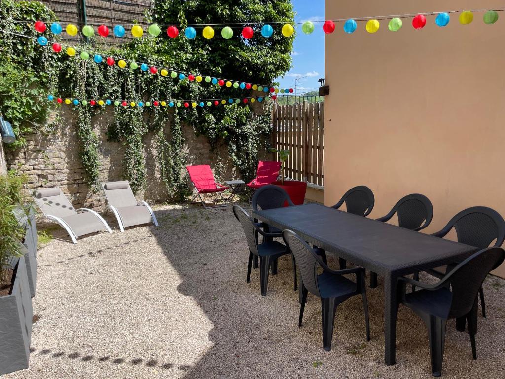 uma mesa preta e cadeiras num quintal com uma cerca em Montbard Maison 7 pers centre historique chez Delphine et Guillaume em Montbard