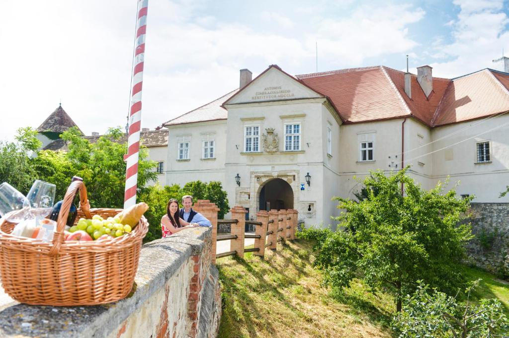 Schlosshotel Mailberg في Mailberg: يجلس شخصان على جدار أمام منزل