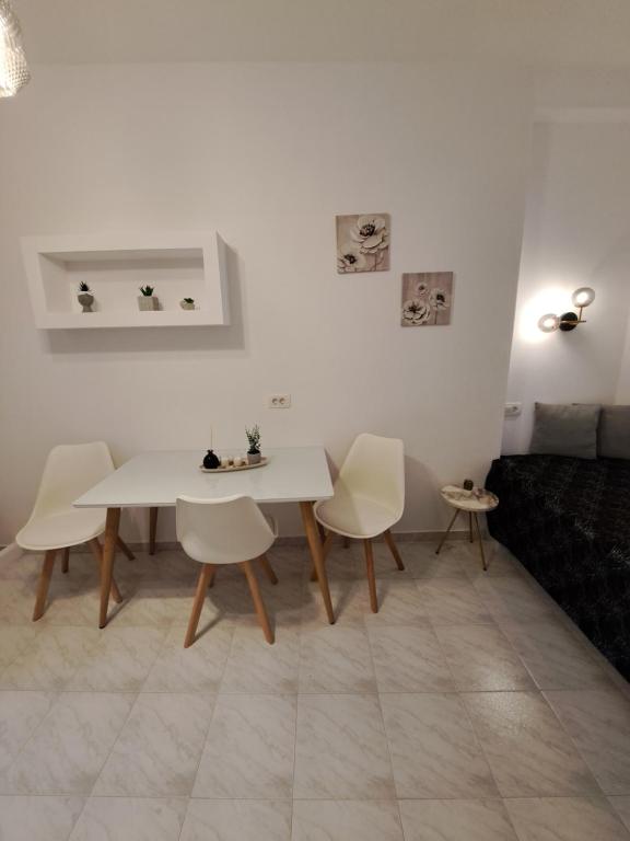 a living room with a white table and chairs at Studios Irineos in Perissa