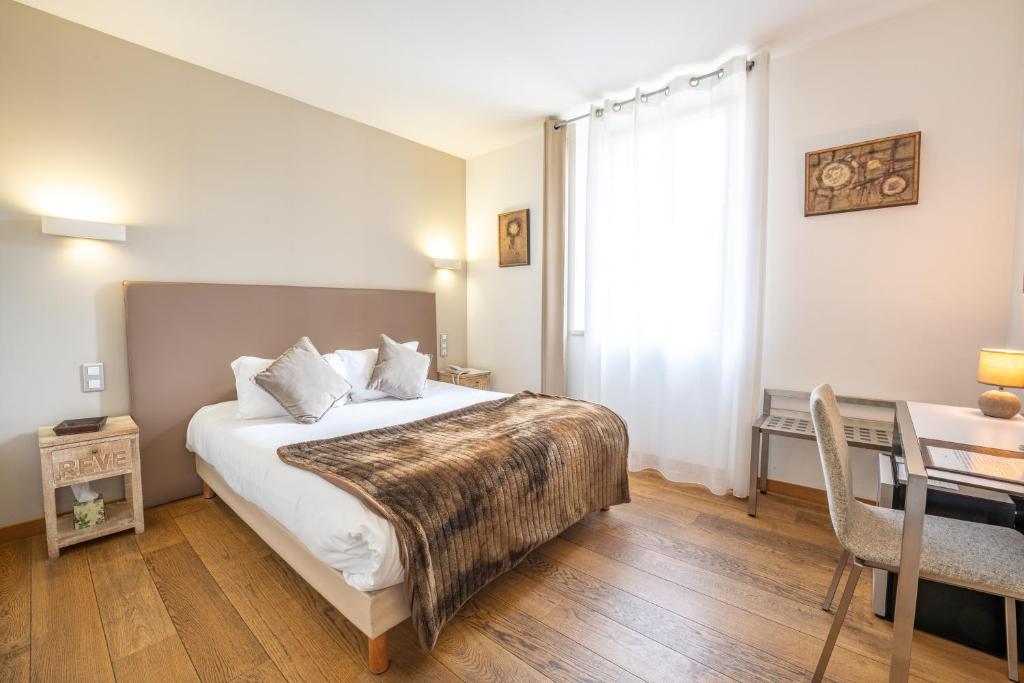 - une chambre avec un lit, une table et un bureau dans l&#39;établissement Le Manoir d&#39;Agnès Logis hôtel restaurant, à Tarascon-sur-Ariège