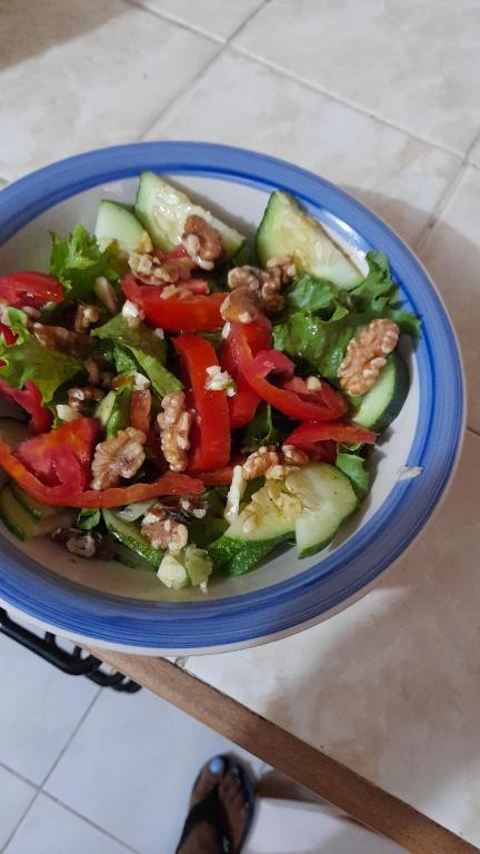 a salad in a blue bowl on a table at Cozy & Comfy in Portmore