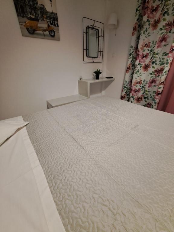 a large white bed in a bedroom with a mirror at Studios Irineos in Perissa