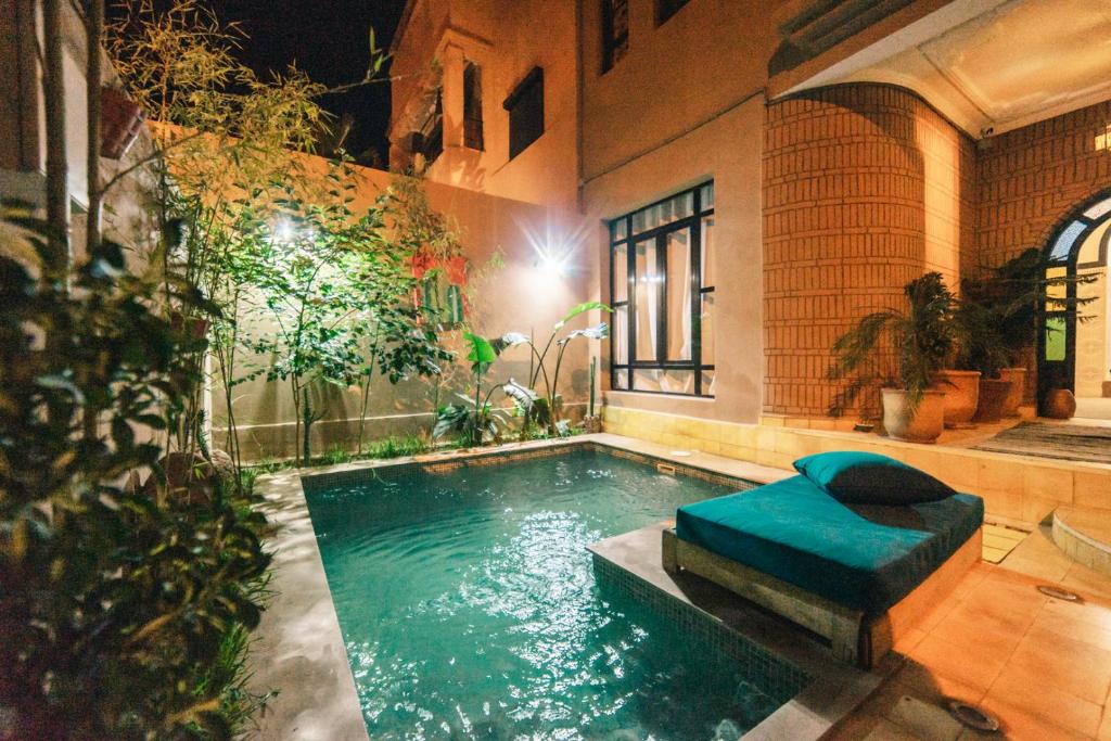 una piscina con reposapiés azul junto a un edificio en The Kozyhome, en Ouarzazate