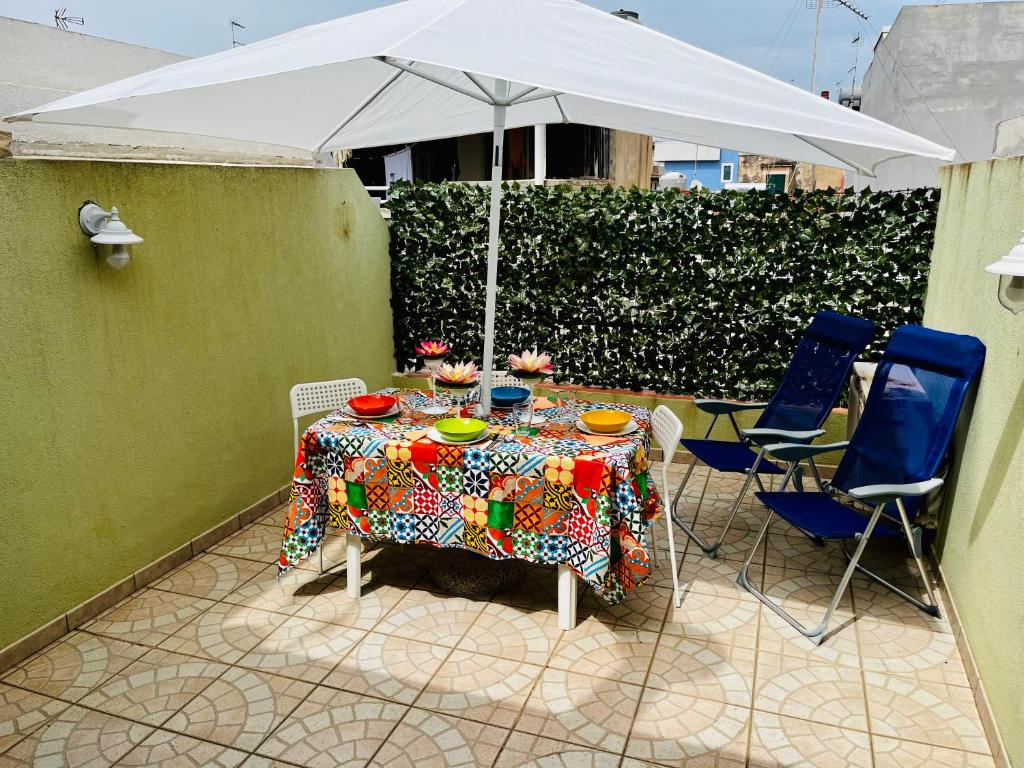 - une table et des chaises avec un parasol sur la terrasse dans l'établissement Pietre Nere House, à Pozzallo