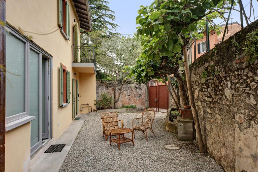 een patio met stoelen en een tafel op een binnenplaats bij Casa romantica in Ispra