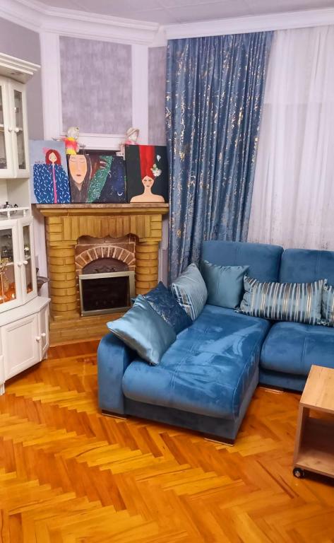 un soggiorno con un divano blu e un camino di Central Apartment 