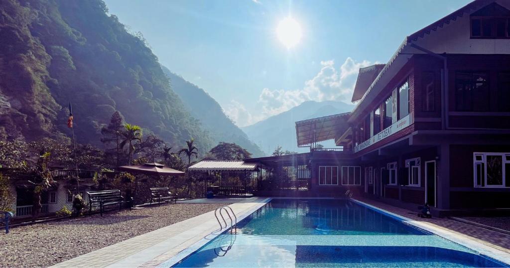a house with a swimming pool next to a mountain at The Mandarine Retreat in Mangan