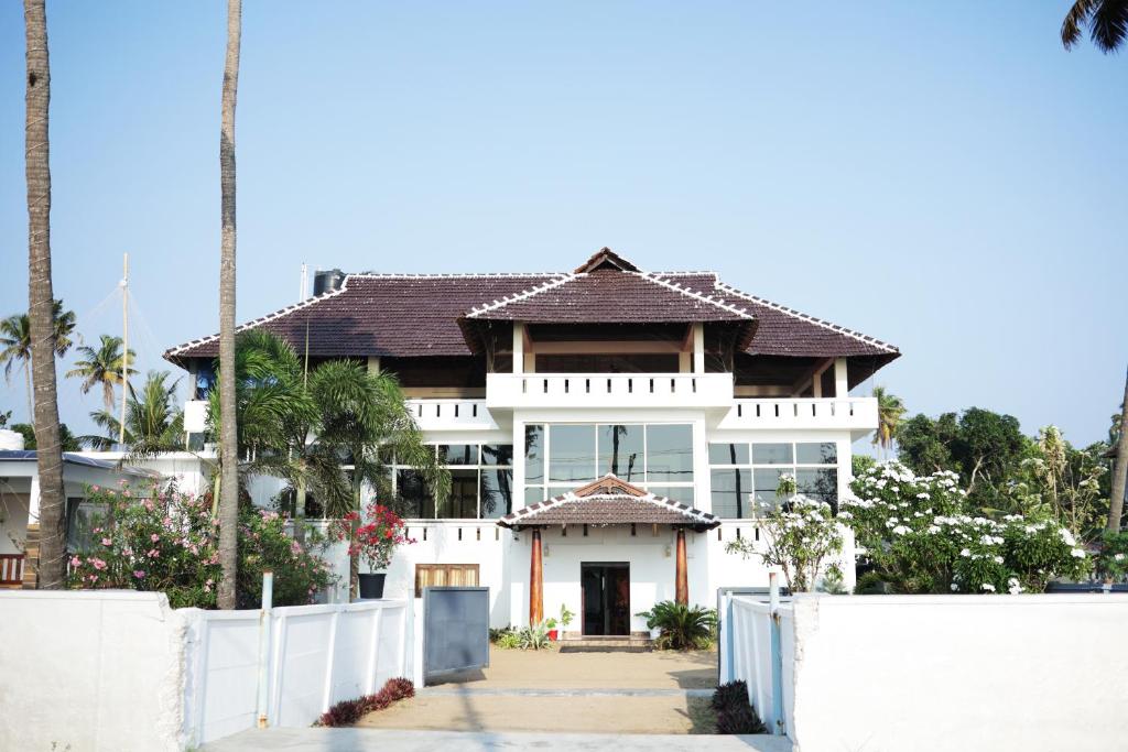 a house with a white fence in front of it at Cherai Beach Palace in Cherai Beach