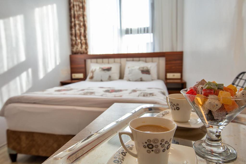 a hotel room with a bed and a table with cups of coffee at Pera Sultan Suit in Istanbul