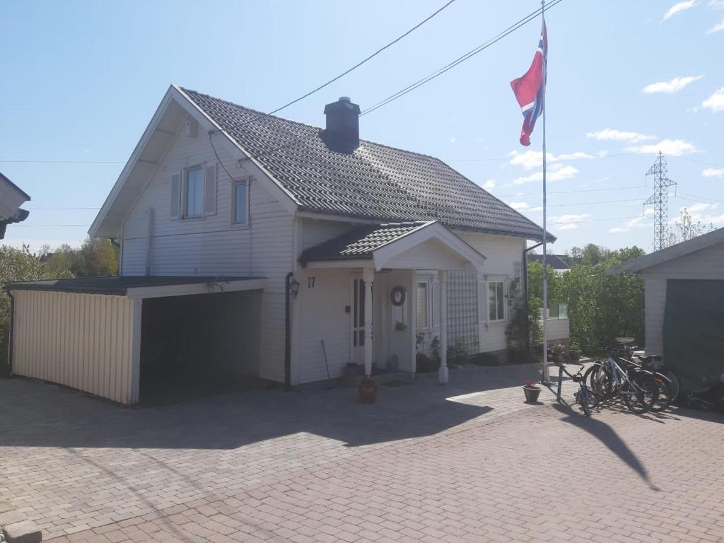 una casa blanca con una bandera delante de ella en Gamle huset på landet en Nøtterøy