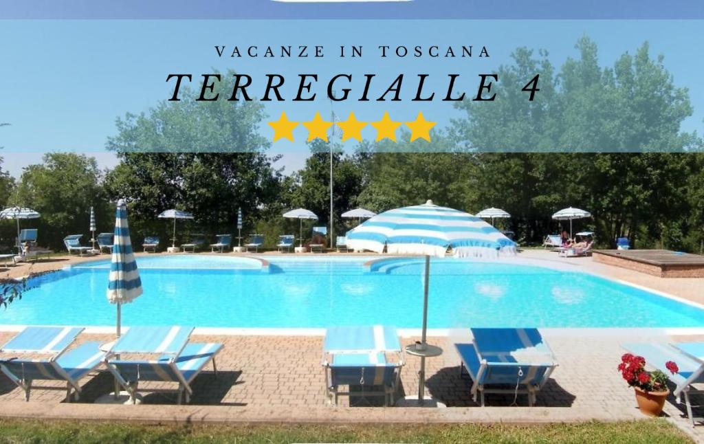une grande piscine avec des chaises et des parasols bleus dans l'établissement Rifugio Rustico Relax in Parco Privato - free parking - privacy TG4, à Castel del Piano
