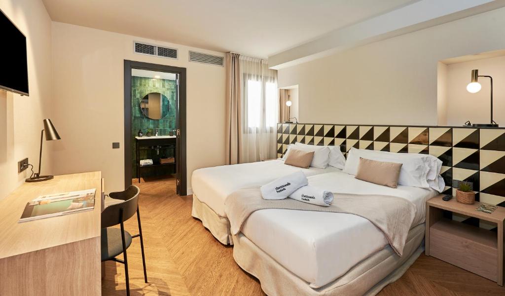 Habitación de hotel con cama grande y TV en The Moods Oasis en Barcelona