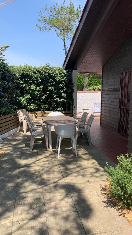 une table et des chaises assises sur une terrasse dans l'établissement patio seignosse plage 6 couchages, à Seignosse