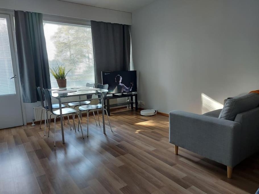 a living room with a table and a couch at Viihtyisä yksiö keskustan lähettyvillä in Oulu
