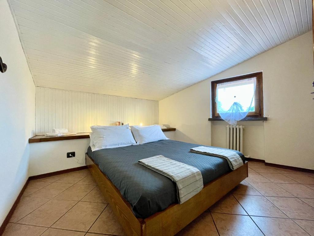 - une chambre avec un lit dans une pièce dotée d'une fenêtre dans l'établissement Chalet Garda, à Peschiera del Garda