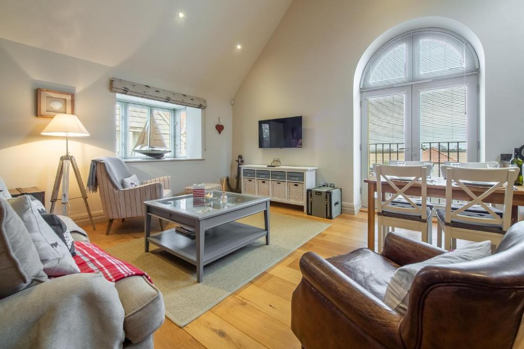 uma sala de estar com um sofá e uma mesa em Tucked Away Cottage em Langham