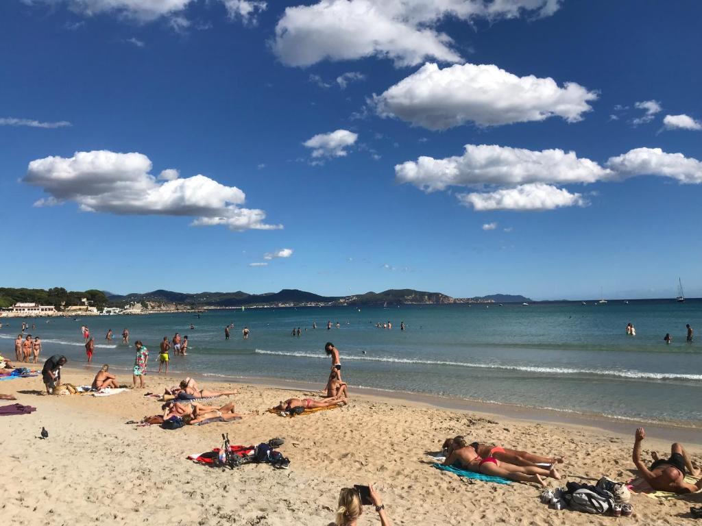 a group of people laying on the beach at Blue Summer Vibes Appartment for 4P, AC, parking, beachfront, SPA access -5 in La Ciotat