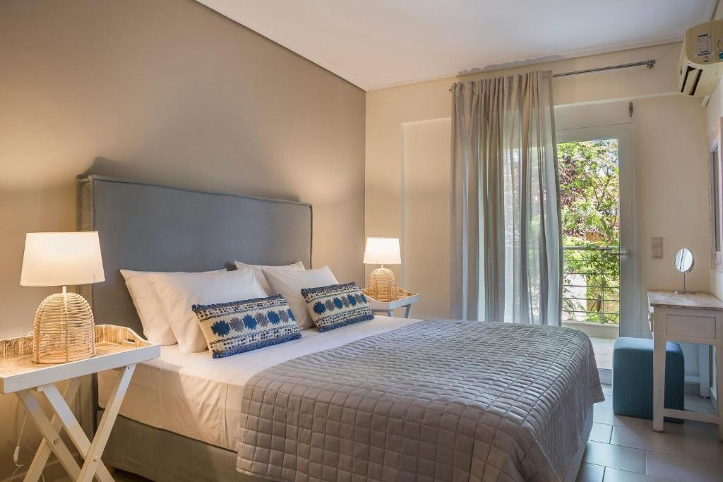 sypialnia z dużym łóżkiem i oknem w obiekcie Waterfront Suites Thalassa Mws Karavomilos Kefalonia w mieście Karavomylos