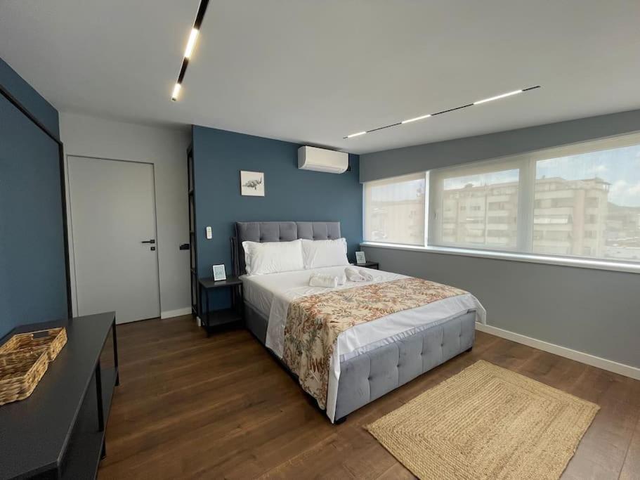 um quarto com uma cama grande e uma janela grande em Voyage Penthouse em Tirana
