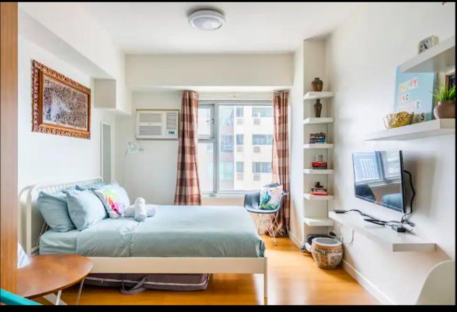 a bedroom with a bed and a television in it at Staycation in Manila (2 min. walk to Robinson's) in Manila