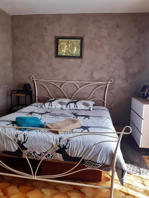 1 cama con marco de metal en un dormitorio en le bois du bournat, en Saint-Avit-Sénieur