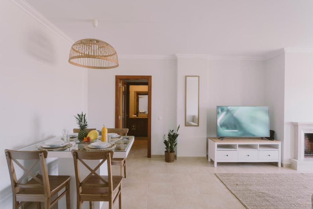 uma sala de estar branca com uma mesa e uma televisão em Best Houses 55 - Surfers Paradise em Ferrel