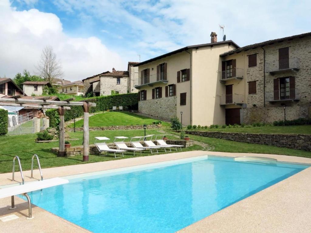 a swimming pool in front of a house at Appartamenti Gli Ippocastani in San Benedetto Belbo