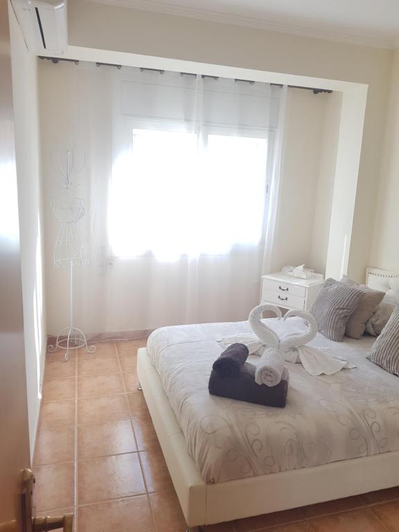 sypialnia z dużym białym łóżkiem i oknem w obiekcie Apt a Calafell plage w mieście Calafell
