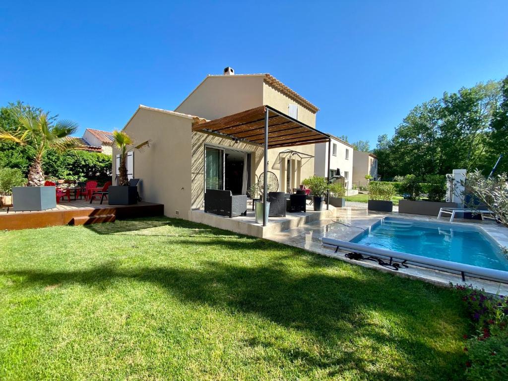 une cour arrière avec une piscine et une maison dans l'établissement Chez Céline, à Saumane-de-Vaucluse