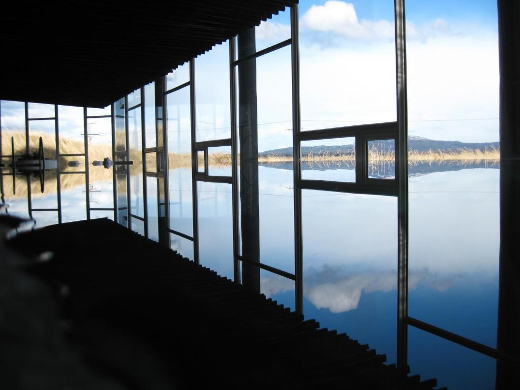 a room with a view of a body of water at Remota Patagonia Lodge in Puerto Natales