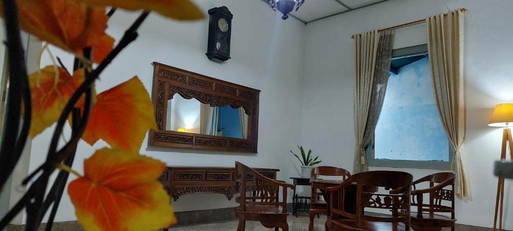 ein Wohnzimmer mit einem Tisch, Stühlen und einem Spiegel in der Unterkunft Omah Tegal Panggung 44 in Sentool