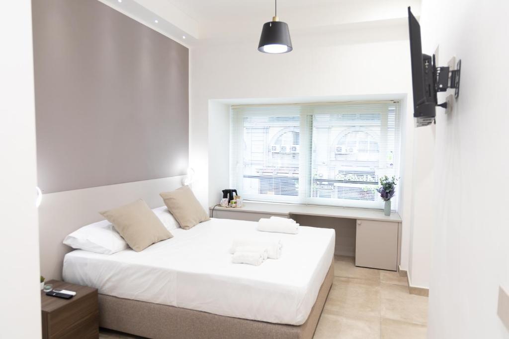 a white bedroom with a bed and a window at CIVICO 237 in Naples