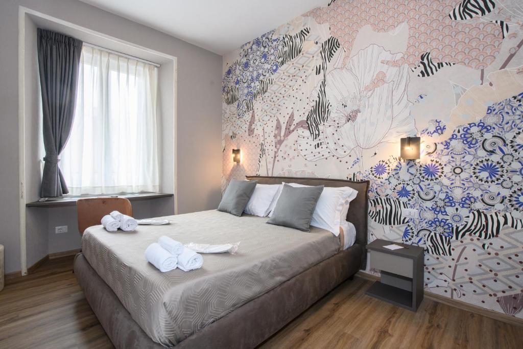 1 dormitorio con 1 cama con pared de flores en Castro Pretorio, en Roma