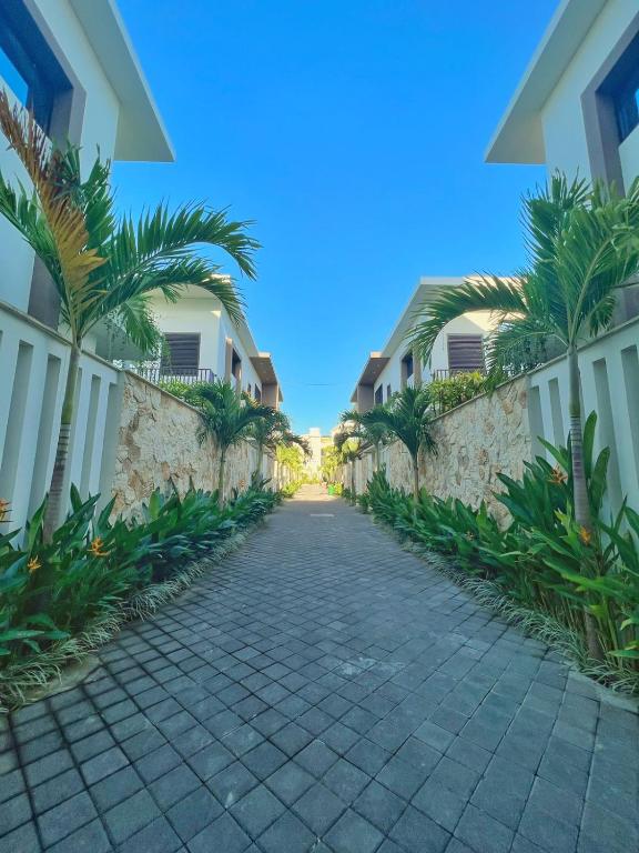 a cobblestone street in front of a building with palm trees at EL Suites Berawa - Canggu in Canggu