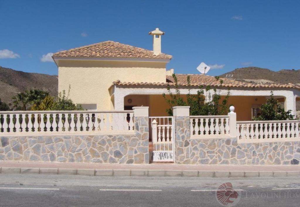 una casa con una valla blanca y una pared de piedra en Bellavista, en Aigües