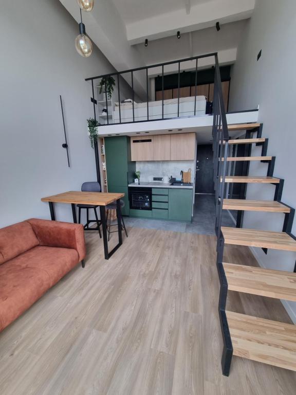 a living room with a staircase and a couch at Cozy Loft in Kaunas
