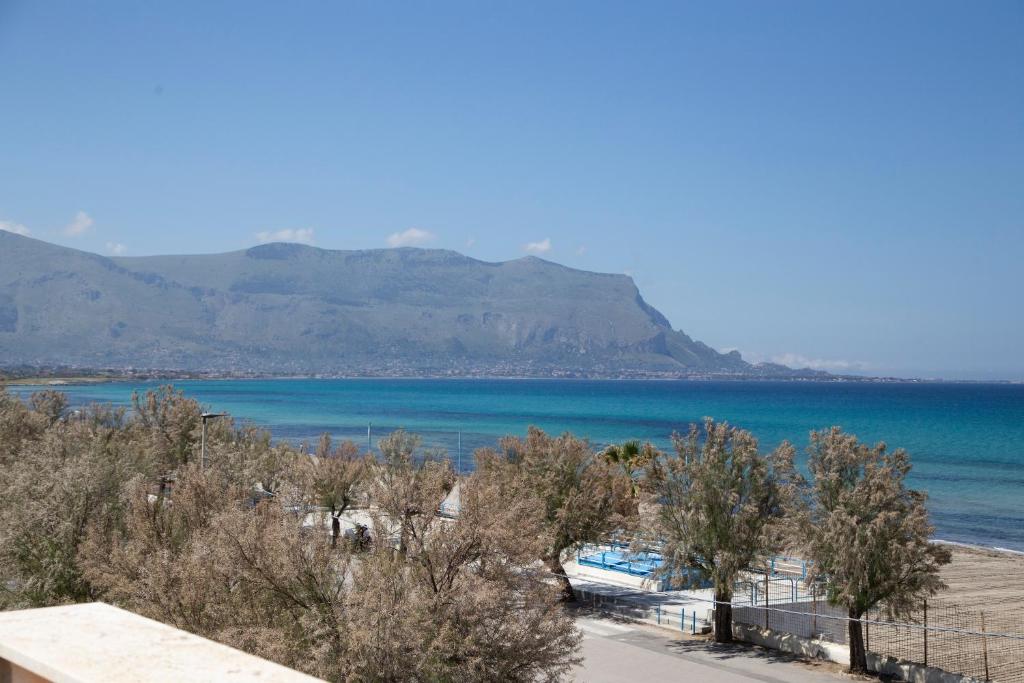 a view of the beach with mountains in the background at AR Palace Hotel - Palermo in Isola delle Femmine