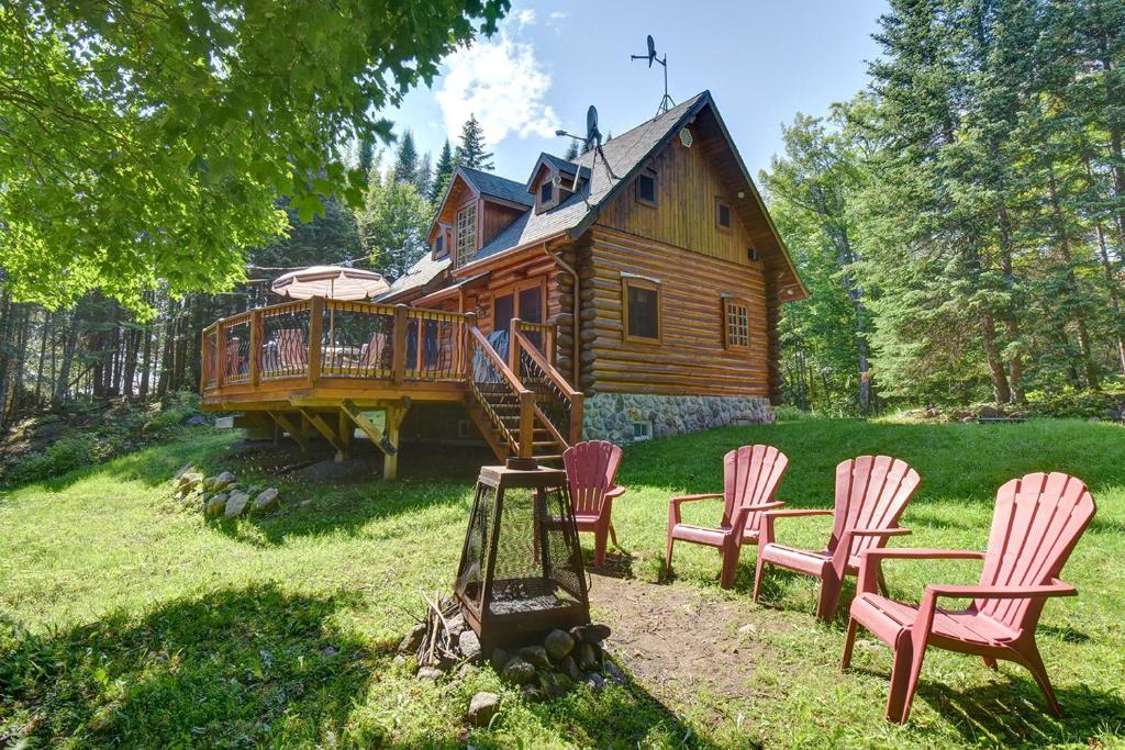 una cabaña de madera con mecedoras frente a ella en Family & Pets Friendly 6 Person Remote Work Mountain View Oasis, en Lac-Supérieur